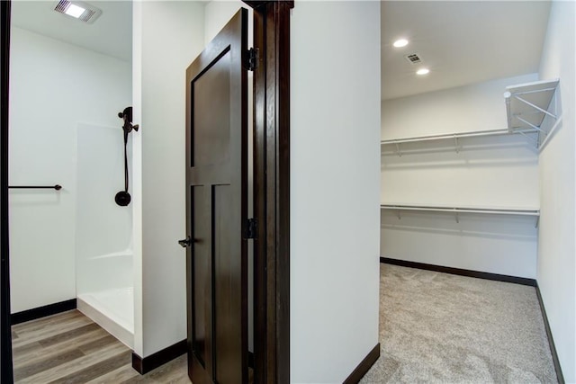 hallway featuring baseboards, visible vents, and recessed lighting