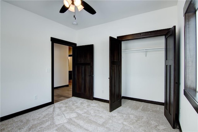 unfurnished bedroom with ceiling fan, baseboards, a closet, and light colored carpet