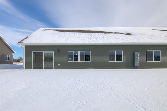 view of snow covered back of property