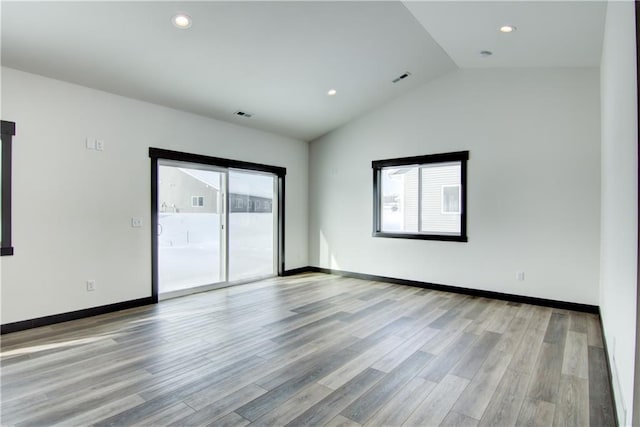 empty room featuring light wood-type flooring, lofted ceiling, baseboards, and recessed lighting