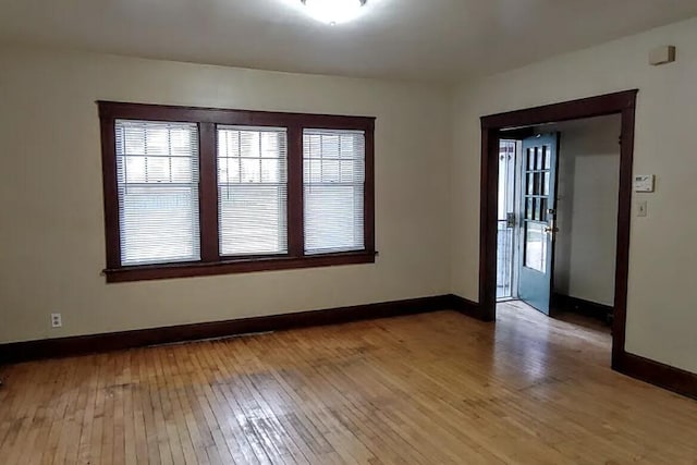 spare room featuring light wood-style flooring and baseboards