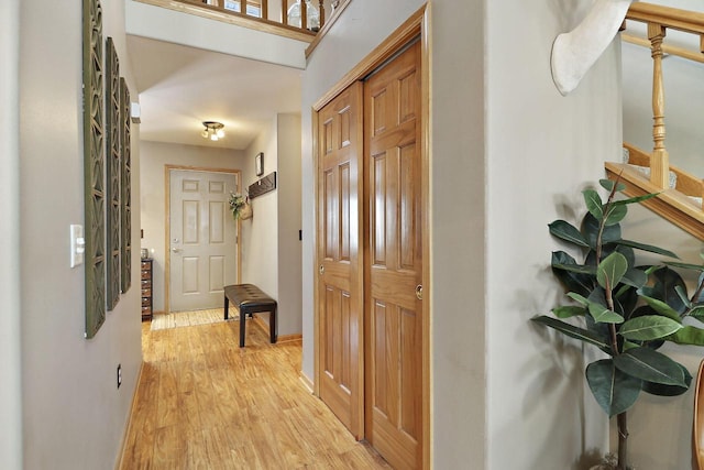 foyer entrance with light wood-style floors and baseboards