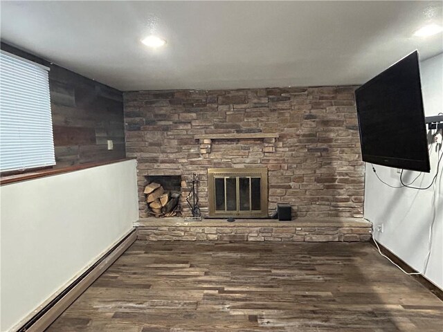 unfurnished living room featuring wood finished floors, a baseboard radiator, and a fireplace