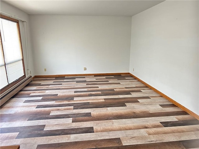 unfurnished room with baseboards and wood finished floors