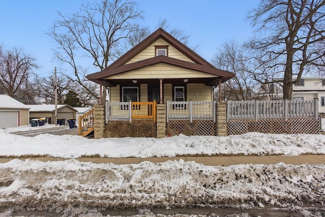 view of front of property with covered porch and a detached garage