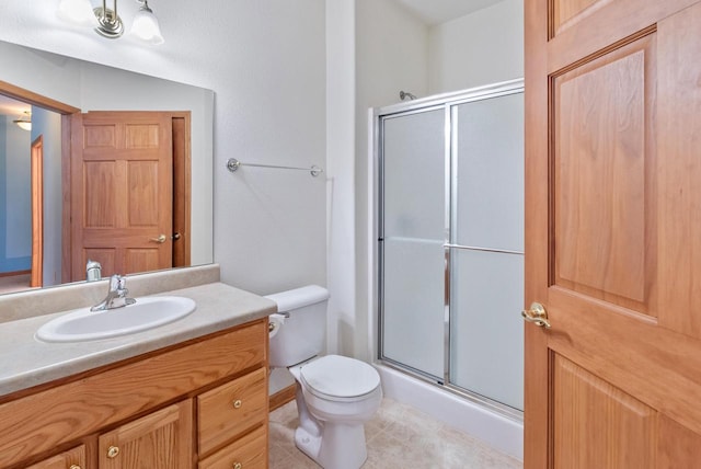 full bathroom featuring toilet, a shower stall, and vanity