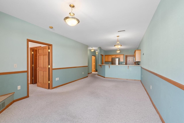 unfurnished living room featuring baseboards, visible vents, and light colored carpet