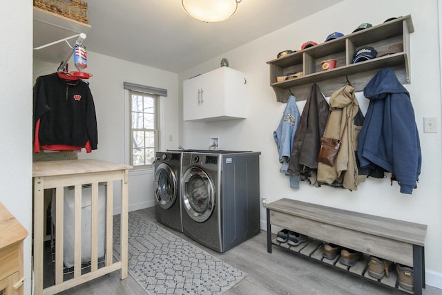 laundry room with washer and dryer, baseboards, cabinet space, and wood finished floors