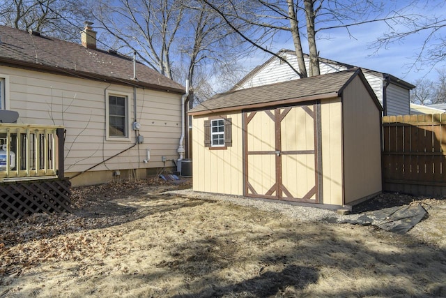 view of shed with central air condition unit and fence