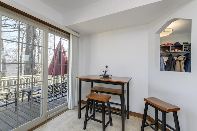 dining space featuring arched walkways and baseboards