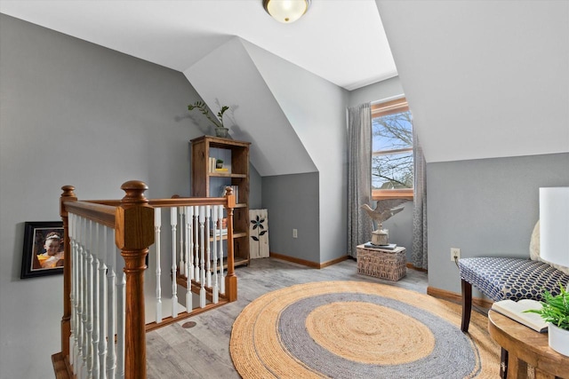 additional living space featuring lofted ceiling, light wood-style floors, and baseboards