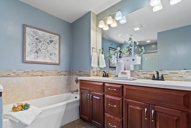 full bath featuring double vanity, a stall shower, backsplash, a sink, and a bath