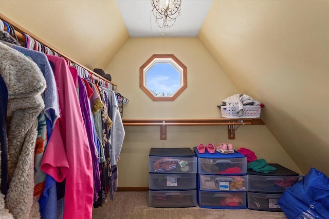 walk in closet with vaulted ceiling and carpet flooring