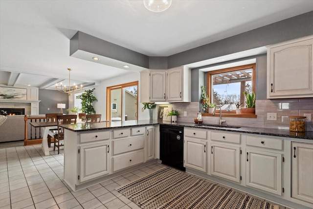 kitchen featuring a peninsula, a sink, white cabinets, black dishwasher, and dark stone counters