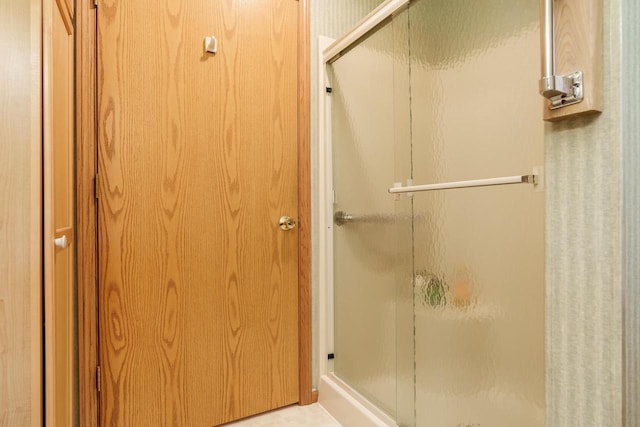 full bathroom featuring a stall shower and a closet