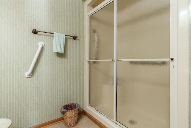 bathroom with a shower stall and wallpapered walls