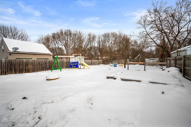 yard layered in snow with a playground and fence