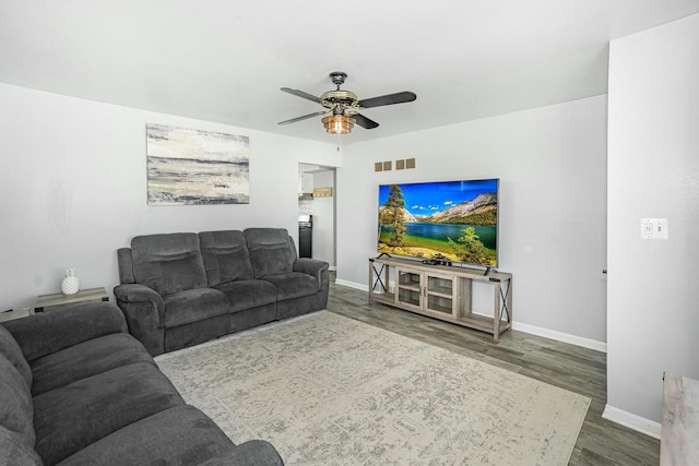 living area with baseboards, visible vents, ceiling fan, and dark wood-type flooring