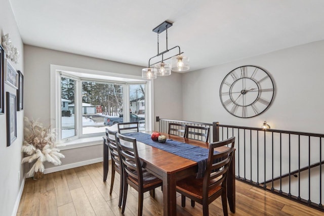 dining space with an inviting chandelier, wood finished floors, and baseboards