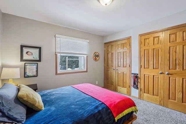 bedroom featuring multiple closets and carpet floors