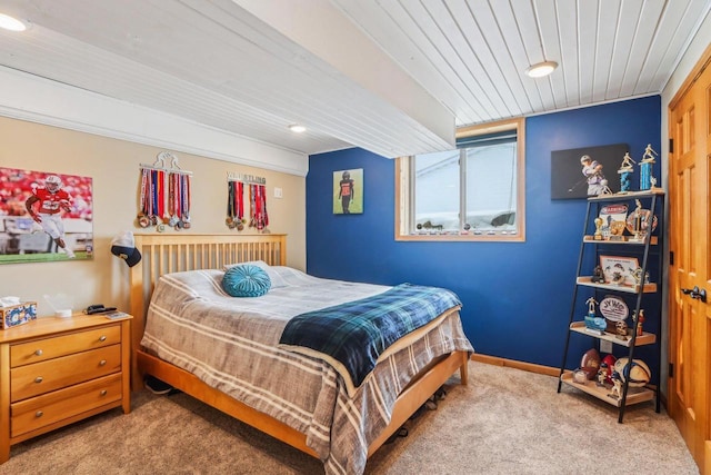 bedroom featuring baseboards, wood ceiling, and carpet