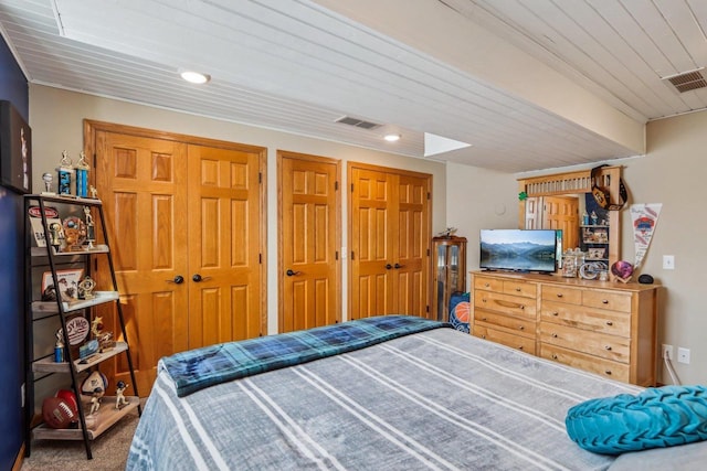 carpeted bedroom with visible vents and wood ceiling