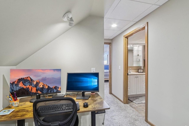 office area with a drop ceiling, baseboards, carpet floors, and a sink