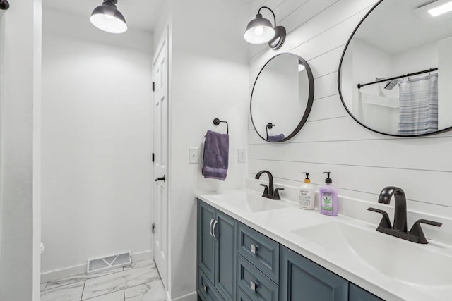 bathroom with visible vents, marble finish floor, baseboards, and a sink