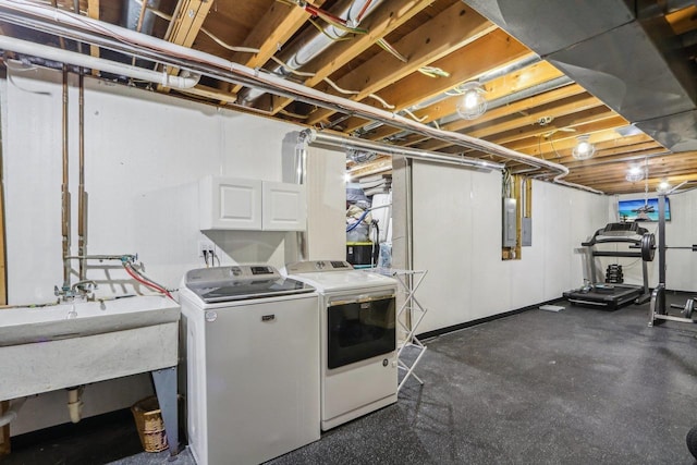 washroom featuring electric panel, independent washer and dryer, and a sink