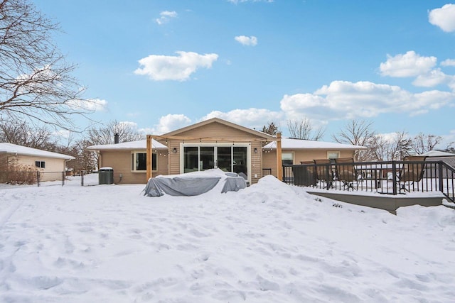 snow covered rear of property featuring fence