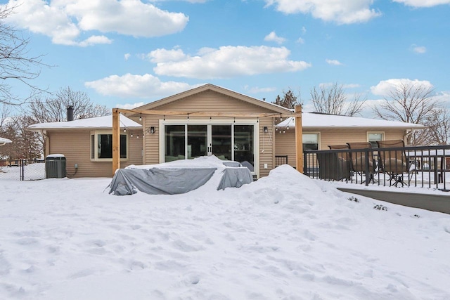 snow covered rear of property with cooling unit and fence