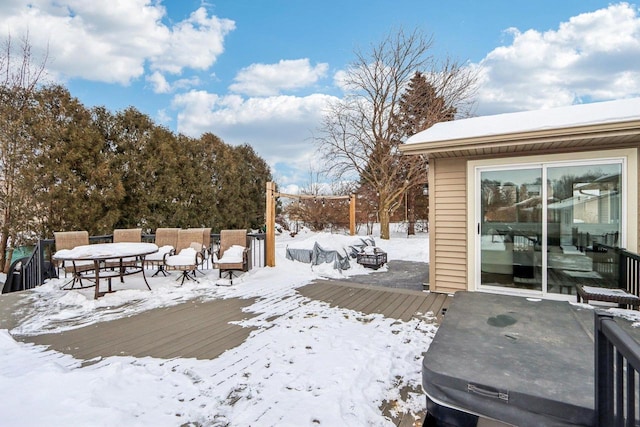 snowy yard with a deck and outdoor dining space