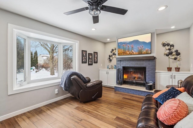 living area featuring recessed lighting, baseboards, wood finished floors, and a fireplace