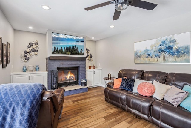 living area featuring recessed lighting, a fireplace, ceiling fan, and wood finished floors