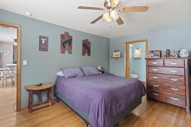 bedroom featuring light wood-style flooring, baseboards, a ceiling fan, and ensuite bathroom