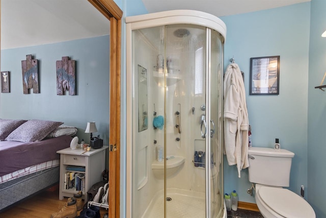 full bath featuring toilet, a shower stall, and wood finished floors