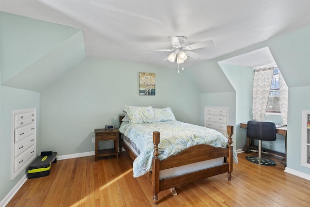 bedroom with light wood-type flooring, vaulted ceiling, baseboards, and ceiling fan