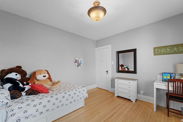 bedroom with light wood finished floors and baseboards