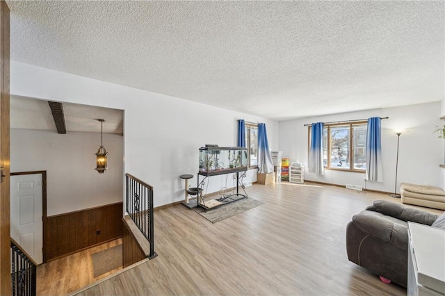 exercise room with a textured ceiling and wood finished floors