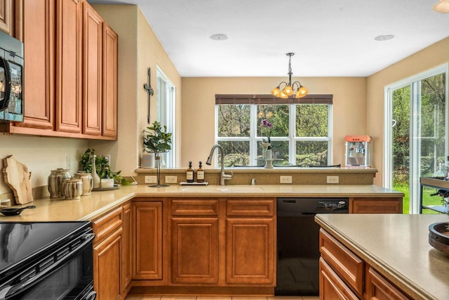 kitchen featuring black appliances, light countertops, a sink, and brown cabinetry