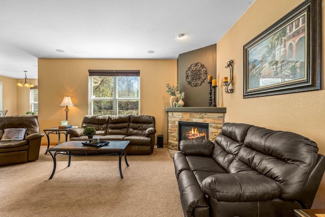 living area featuring a stone fireplace and carpet