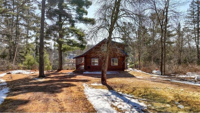 view of home's exterior with a forest view and log exterior