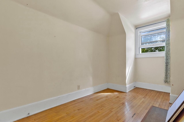 bonus room featuring light wood-style flooring and baseboards