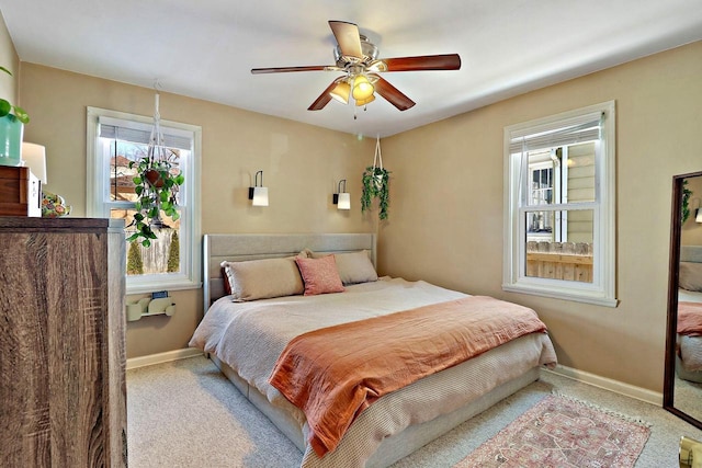 bedroom with light carpet, ceiling fan, and baseboards