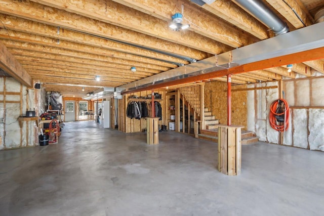 basement featuring stairs and freestanding refrigerator