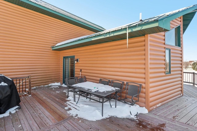 wooden terrace with outdoor dining area and area for grilling