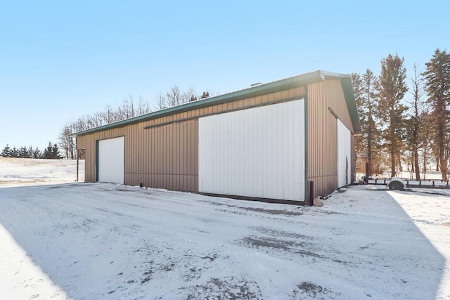 snow covered garage featuring a garage