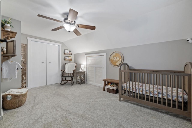 bedroom featuring a ceiling fan, lofted ceiling, carpet flooring, a nursery area, and a closet