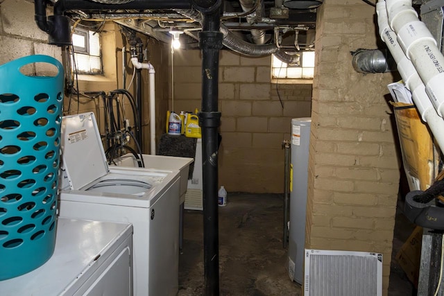 clothes washing area with laundry area, water heater, and independent washer and dryer