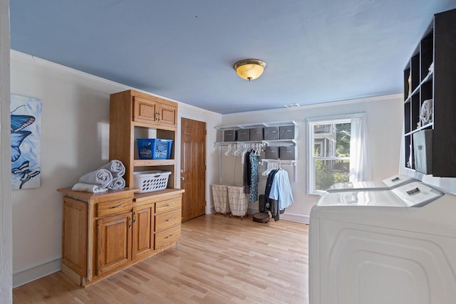 laundry room with laundry area, light wood finished floors, crown molding, and independent washer and dryer